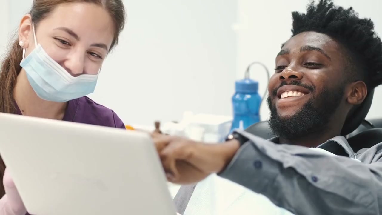 Dentist and smiling patient reviewing a care plan together