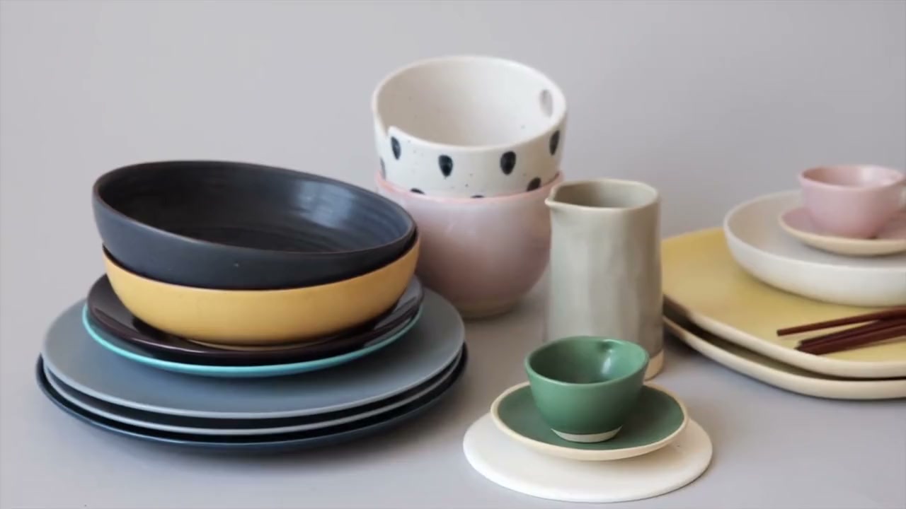 Colorful handcrafted ceramic tableware arranged in a studio